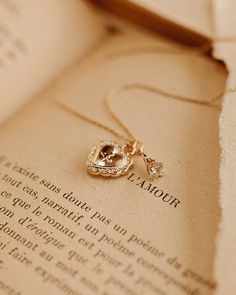 an open book with a gold crown on it and a necklace hanging from the front