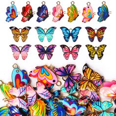 many colorful butterflies are on display in the shape of keychains and pendants