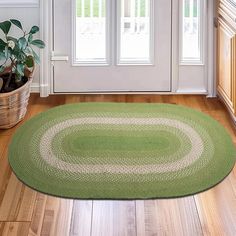 a green rug in front of a door with potted plants on the floor next to it