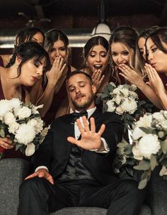 a group of bridesmaids and groomsmid posing for a photo with their hands in the air