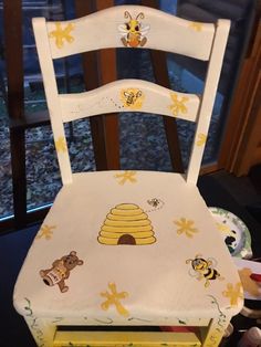 a wooden chair with bees and honeycombs painted on it