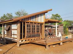 a small wooden house sitting on top of a dirt field