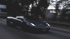 a black sports car driving down the road