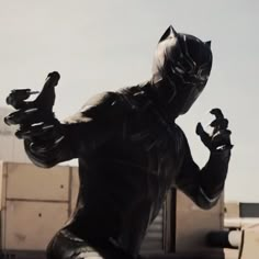 a statue of a black cat is in front of a building and has his hands out