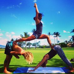 two people doing yoga in the grass