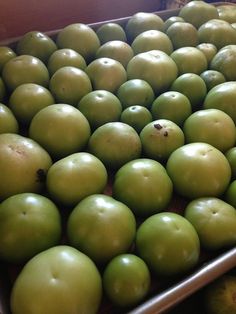 green apples are sitting in a metal pan