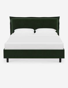 a bed with white sheets and green headboard