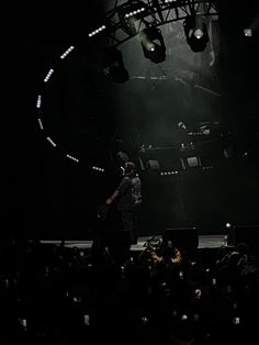 a man standing on top of a stage in front of a crowd at a concert