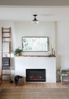 a living room with a fire place next to a wall mounted art on the wall