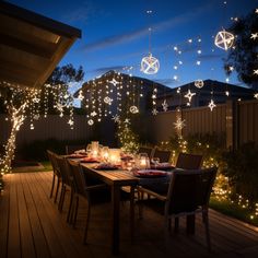 an outdoor dining table is lit up with christmas lights and hanging decorations on the deck