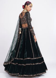 Features a green tiered lehenga in velvet with embroidered detail teamed with a full sleeved classic hand embroidered blouse in luxurious velvet. Completed with a matching soft net dupatta Composition : Lehenga - Velvet, Dupatta - Net, Blouse - Velvet, Lining - Silk Blend Care: Dry Clean Only and Vacuum Storage This product can be customised for sleeves, length of blouse and neckline Delivery : 4-6 weeks as the product is hand crafted. For more information and sizes please contact fabiliciousfashion@gmail.com or visit our Copenhagen studio.About the Designer : Introducing Vvani by Vani Vats, the ultimate choice for millennial fashionistas. Experience the allure of dazzling shades, intricate embroidery, and exquisite embellishments with Vvani Vats' collection of lehengas, kurta sets and sar Vani Vats, Velvet Dupatta, Velvet Lehenga, Lehenga Dupatta, Net Blouses, Green Lehenga, Net Dupatta, Lehenga Designs, Bridal Lehenga