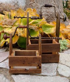 three wooden planters sitting on top of a stone floor next to a tree and yellow leaves