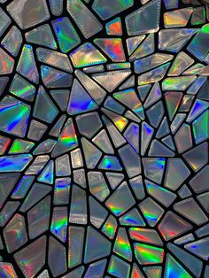 an abstract mosaic pattern made up of many different colors and shapes, including iridescents