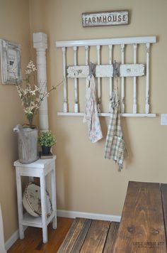 a wooden bench sitting in front of a wall mounted coat rack and potted plant