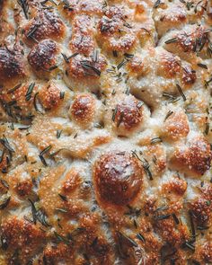 a close up view of some bread with cheese and sprigs on the top