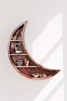 a wooden moon shelf with books and pictures on it