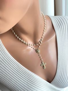 This is a beautiful pearl gold-filled rosary necklace made for women. This is a double strand pearl necklace made with 4 mm freshwater pearls on 14k gold filled chain. Both strands connect in back with a spring clasp.  Necklace charms are 18k gold filled. Beautiful Saint Michael rosary center measures 19 x 12 mm. Drop with cross measures, 3". This sparkling crucifix cross has pave crystals and measures 30 x 21 mm.  Necklace on model is 15 inch length. The length is the measurement of the top strand, around your neck. Please choose your desired length. It's always best to measure your neck since people have different neck sizes. Model in picture has a very slender neck. Comes in a gift box ready to present. Elegant Pearl Crucifix Necklace, Elegant Crucifix Pearl Necklace, Elegant Crucifix Necklace With Pearl Pendant, Elegant Crucifix Pearl Pendant Necklace, Elegant Gold Rosary As Gift, Elegant Gold Rosary For Gift, Elegant White Crucifix Pearl Necklace, Elegant Pearl White Jewelry For First Communion, Elegant Miraculous Medal Necklace