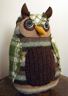 an owl stuffed animal sitting on top of a wooden table