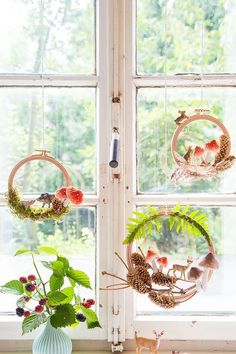 three wreaths are hanging on the window sill