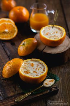 some oranges are cut in half and placed on a cutting board with spoons