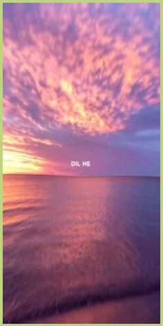 the sky is pink and purple with some clouds above it, as seen from an ocean shore