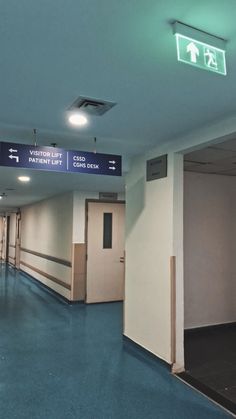 an empty hallway with blue floors and signs on the walls that read, welcome to patient lift