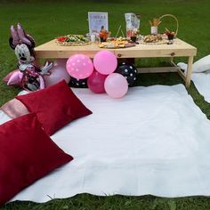 a picnic table with balloons and snacks on it