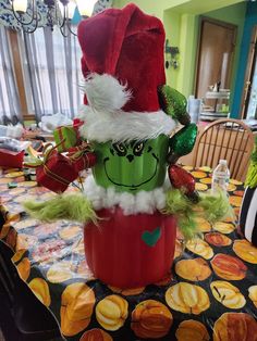 a table topped with a green and red potted plant sitting on top of a table