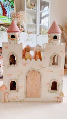 a castle made out of clay sitting on top of a white table next to a vase