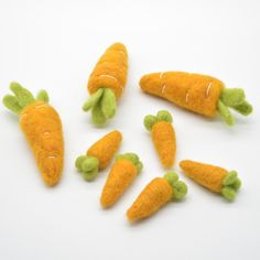 several felt carrots are shown on a white surface