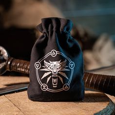 a black bag with a white design on it sitting on top of a wooden table