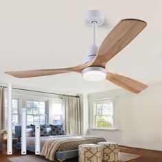 a bed room with a neatly made bed and a ceiling fan in the middle of it