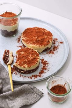 two small desserts on a plate with some powdered sugar next to one and another