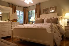 a white bed sitting in a bedroom next to two lamps on either side of the bed