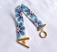 two blue and white beaded keychains with gold metal clasps on a white background