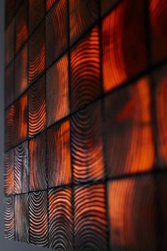 an abstract wall made up of orange and brown circles on it's side, reflecting light