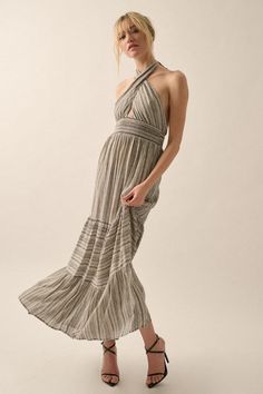 A abstract striped woven maxi dress with a halter neckline, mocked high-waist band, tiered ruffle design, and an open back. Model Info:Height: 5 ft 9.5 in | Bust: 31 in | Waist: 23 in | Hips: 33 in | Wearing Size Small Material: 100% Rayon Striped Halter Neck Sundress, Ruffled Halter Neck Sundress, Bohemian Backless Ruffled Maxi Dress, Spring Halter Maxi Dress With Ruffles, Flowy Halter Neck Maxi Dress With Ruffles, Spring Maxi Length Halter Dress With Ruffles, Striped Beach Dress With Smocked Back, Chic Striped Tiered Dress, Striped Halter Neck Maxi Dress For Beach