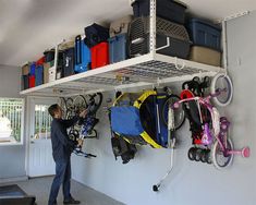 a man standing in front of a wall filled with lots of luggage and bike parts