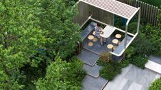 a person sitting on a bench in the middle of some trees and bushes next to an outdoor dining area