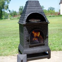 an outdoor wood burning oven in the grass