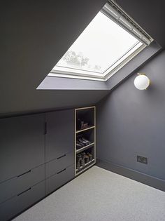 an attic bedroom with skylight and storage cabinets