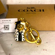 a gold and black bear keychain sitting on top of a table next to a cardboard box