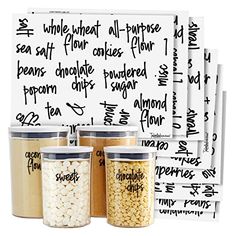 four jars with different types of food in them next to a white board that has writing on it