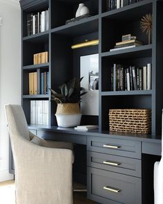 a desk with a chair and bookshelves in front of it