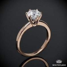 an engagement ring with a princess cut diamond in the center, on a black background