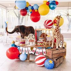 an elephant, giraffe and zebra are on display at a circus themed birthday party