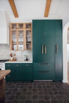 a kitchen with green cabinets and white walls