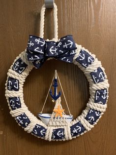 a blue and white wreath with an anchor on it hanging from the side of a door