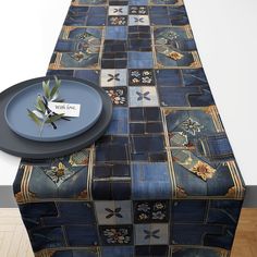 a blue table cloth with patchwork designs on it and a plate next to it