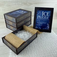 three books sitting on top of each other next to an ice puzzle box filled with ice